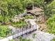 Scenic walking path with a small bridge, surrounded by lush greenery and rock features at 310 Patterson Ave, Mooresville, NC 28115