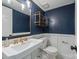 Stylish half bath features navy walls, white trim, a pedestal sink, and gold accents at 3101 Willowbrae Rd, Charlotte, NC 28226