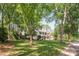 This charming two-story home is surrounded by mature trees and a lush green lawn at 3101 Willowbrae Rd, Charlotte, NC 28226
