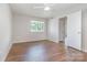 Bedroom with hardwood floors, window with view of trees, and closet off of the hallway at 3201 Heathstead Pl # C, Charlotte, NC 28210