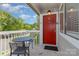 Cozy balcony with a table, chairs, and a vibrant red front door at 3201 Heathstead Pl # C, Charlotte, NC 28210