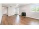 Open-concept living room with hardwood flooring, fireplace, ceiling fan, and bright windows at 3201 Heathstead Pl # C, Charlotte, NC 28210