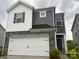 Two-story home featuring gray and white siding, stone accents, and a two-car garage at 345 Hyssop Ct, Fort Mill, SC 29715
