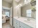 Bathroom with double sinks, neutral paint, large mirror, and an adjacent bedroom at 509 Silers Bald Dr, Fort Mill, SC 29715