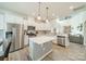Bright and airy kitchen with white cabinets, stainless appliances, island, and open to living area at 509 Silers Bald Dr, Fort Mill, SC 29715