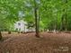 Large backyard featuring a patio area and a fire pit nestled within a wooded lot at 5308 Lambert Ct, Waxhaw, NC 28173