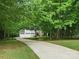 Long driveway leading to a charming home with a three-car garage, surrounded by lush trees at 5308 Lambert Ct, Waxhaw, NC 28173