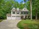 Inviting two-story home with a three-car garage and a welcoming front porch, surrounded by mature trees at 5308 Lambert Ct, Waxhaw, NC 28173