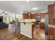 Open-concept kitchen with stainless steel appliances, wood cabinets, and a breakfast bar overlooking the living area at 5308 Lambert Ct, Waxhaw, NC 28173