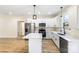 A well-lit kitchen boasts stainless steel appliances, white cabinets, and wood-look flooring at 605 Stirewalt Rd, China Grove, NC 28023