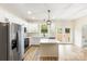 Open kitchen with stainless steel appliances, white cabinets, a center island, and a view to the yard at 605 Stirewalt Rd, China Grove, NC 28023