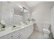 Well-lit bathroom with double vanity, large mirror, updated fixtures, and tile flooring at 614 Stone Village Dr, Fort Mill, SC 29708