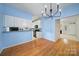Open dining area next to kitchen has white cabinets, modern lighting, and wood floors at 614 Stone Village Dr, Fort Mill, SC 29708