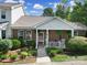 Charming townhome with covered porch, lush landscaping, and walkway to the front entrance at 614 Stone Village Dr, Fort Mill, SC 29708