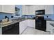 Well-lit kitchen featuring white cabinets, black appliances, and granite countertops at 614 Stone Village Dr, Fort Mill, SC 29708