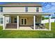 Spacious backyard featuring a covered patio with outdoor seating and hot tub, perfect for relaxation at 6314 Bluffton Ln, Midland, NC 28107