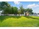 Large, grassy backyard featuring a storage shed and mature trees at 6314 Bluffton Ln, Midland, NC 28107