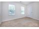 Bedroom with neutral carpet, two bright windows, and a closet door at 6717 Ware Rd, Charlotte, NC 28212