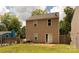 Back of the two story home, featuring a grassy area and trees at 6717 Ware Rd, Charlotte, NC 28212