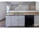 Bright kitchen featuring granite countertops, white cabinetry, and a black dishwasher at 6717 Ware Rd, Charlotte, NC 28212