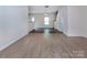 Open-concept living space with wood floors, neutral walls, and an open staircase at 6717 Ware Rd, Charlotte, NC 28212