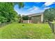 Fenced backyard with large lawn, covered deck, brick home and mature trees at 7020 Cedar Ridge Ct, Mount Holly, NC 28120