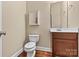 Stylish half bathroom featuring wood-look flooring and a modern vanity with a decorative mirror at 7020 Cedar Ridge Ct, Mount Holly, NC 28120