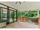 Spacious deck with wooden flooring leading to a bright sunroom and private, wooded backyard at 7020 Cedar Ridge Ct, Mount Holly, NC 28120