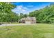 Well-manicured front yard with a long driveway leading to a brick home with mature landscaping at 7020 Cedar Ridge Ct, Mount Holly, NC 28120