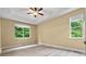 Main bedroom with large windows, tray ceiling, fan and neutral colored walls at 7020 Cedar Ridge Ct, Mount Holly, NC 28120