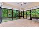Bright sunroom with wood flooring, a ceiling fan, and large windows offering wooded views at 7020 Cedar Ridge Ct, Mount Holly, NC 28120