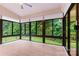 Bright sunroom with wood flooring and large windows offering wooded views at 7020 Cedar Ridge Ct, Mount Holly, NC 28120