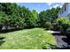 Well-maintained backyard featuring lush green grass, mature trees, and a partial fence at 7245 Willow Brook Ct, Denver, NC 28037