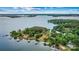 Stunning lakefront property surrounded by mature trees and lush landscaping with multiple docks at 8218 Bright Water Ln, Denver, NC 28037