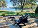 Outdoor seating area with chairs and a fire pit overlooking the tranquil lake views at 8218 Bright Water Ln, Denver, NC 28037