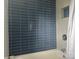 Modern bathroom with sleek blue subway tile and a shower niche for toiletries at 8218 Bright Water Ln, Denver, NC 28037
