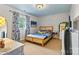 Cozy bedroom with light blue walls, wooden bed frame, and window with patterned curtains at 8218 Bright Water Ln, Denver, NC 28037