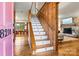 Warm entryway featuring hardwood floors, an elegant staircase, and a view of the inviting living room at 8218 Bright Water Ln, Denver, NC 28037