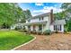 Charming two-story home with a cozy front porch, swing, manicured lawn, and beautiful landscaping at 8218 Bright Water Ln, Denver, NC 28037
