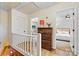 Upstairs hallway showcasing hardwood floors, patterned wallpaper, and a glimpse of the bedrooms at 8218 Bright Water Ln, Denver, NC 28037