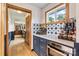 Stylish wet bar with blue cabinets, quartz countertop, and modern appliances, perfect for entertaining guests at 8218 Bright Water Ln, Denver, NC 28037