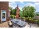 Enjoy outdoor dining on the spacious deck with an umbrella-covered table and views of the landscaped yard and fireplace at 8962 Landsdowne Ave, Harrisburg, NC 28075