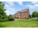 Gorgeous brick home with a well-maintained lawn and landscaping, offering a serene backyard setting at 8962 Landsdowne Ave, Harrisburg, NC 28075