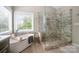 Bathroom showcasing a modern soaking tub and tiled glass shower at 8962 Landsdowne Ave, Harrisburg, NC 28075