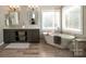 Bright bathroom features a soaking tub, tile accents, and dual sink vanity at 8962 Landsdowne Ave, Harrisburg, NC 28075
