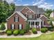 Stunning aerial view of the two-story brick home with lush greenery at 8962 Landsdowne Ave, Harrisburg, NC 28075