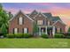 Charming two-story brick home with a well-manicured lawn and landscaping at 8962 Landsdowne Ave, Harrisburg, NC 28075