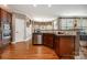 Open kitchen featuring a breakfast bar, stainless steel appliances, and hardwood floors at 8962 Landsdowne Ave, Harrisburg, NC 28075