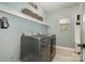 Well-lit laundry room featuring a modern washer and dryer with a convenient storage shelf at 8962 Landsdowne Ave, Harrisburg, NC 28075