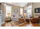 Bright living room with large windows, comfortable seating, and stylish decor at 8962 Landsdowne Ave, Harrisburg, NC 28075